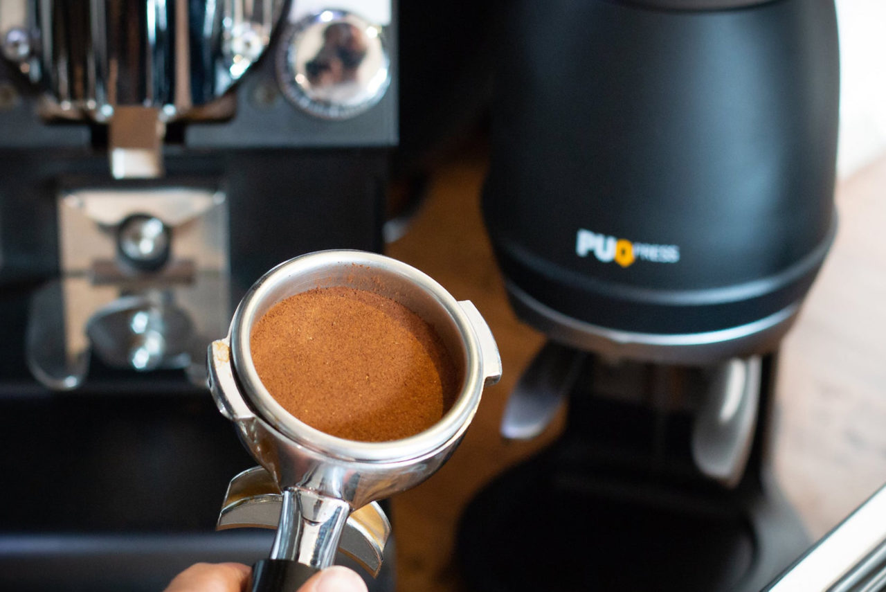 Puqpress voor het optimaal temperen van koffie